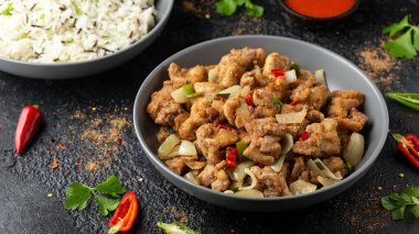 Çin tuzu ve biberli tavuğu gri kasede pilavla karıştır.