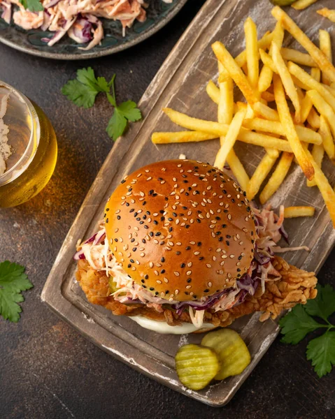 Hambúrguer de frango frito, sanduíche com salada de repolho, pepinos em conserva, maionese e cerveja. Fast food. — Fotografia de Stock