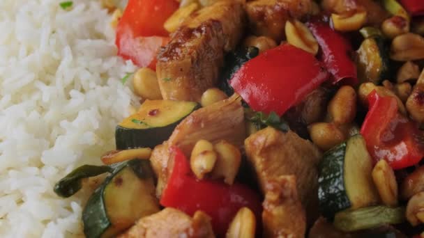 Kung Pao Kip met pepers, courgette en rijst. roterende video — Stockvideo