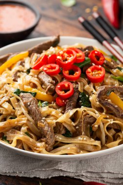 Kızarmış sığır eti, erişte, fasulye filizi, taze soğan ve biber ile karıştırın..