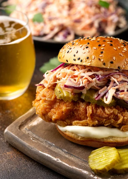 Hambúrguer de frango frito, sanduíche com salada de repolho, pepinos em conserva, maionese e cerveja. Fast food. — Fotografia de Stock