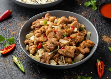 Çin tuzu ve biberli tavuğu gri kasede pilavla karıştır.