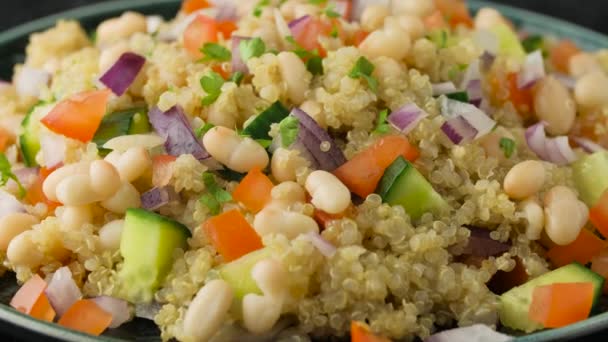 Quinoa witte bonensalade met kerstomaten, komkommer, rode ui en kruiden. Gezond veganistisch voedsel. roterende video — Stockvideo