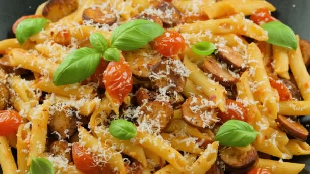 Korvpenne Pasta med tomatsås, parmesanost och basilika. roterande video — Stockvideo