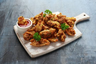 Beyaz tahta üzerinde acı biber soslu tavuk Pakora yemeği.