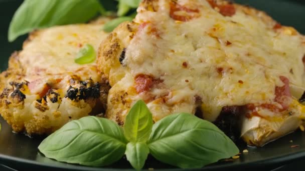 Baked Cauliflower steak with marinara sauce and cheese on plate. Healthy vegetarian food. rotating video — Stockvideo