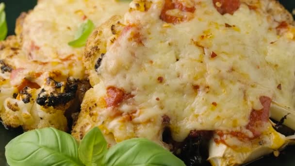 Baked Cauliflower steak with marinara sauce and cheese on plate. Healthy vegetarian food. rotating video — Stockvideo