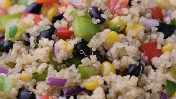 Quinoa svarta bönsallad med majs, röd grön paprika, lök. Friska livsmedel. roterande video. — Stockvideo
