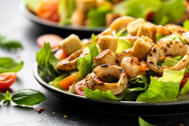 Izgara kalamar veya kalamar ve sarımsaklı ekmek ve kiraz domatesli karides salatası. sağlıklı yiyecekler.