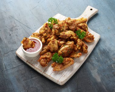 Beyaz tahta üzerinde acı biber soslu tavuk Pakora yemeği..