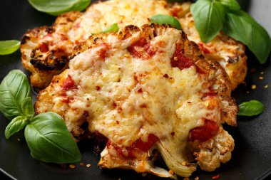 Marinara soslu ve peynirli fırında karnabahar bifteği. Sağlıklı vejetaryen yemekleri.