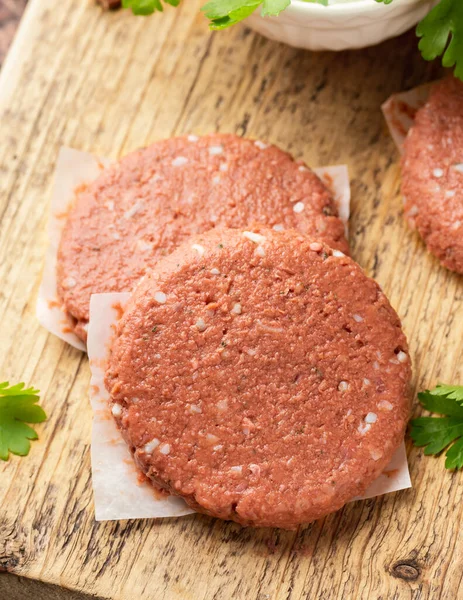 Chuletas sin carne vegana cruda, hamburguesa sobre tabla de madera. listo para cocinar — Foto de Stock