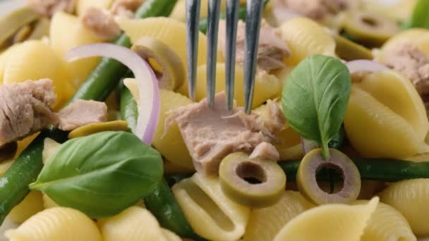 Выбор тунец conchiglie макароны с зеленой фасолью, оливки и красный лук с помощью вилки. — стоковое видео