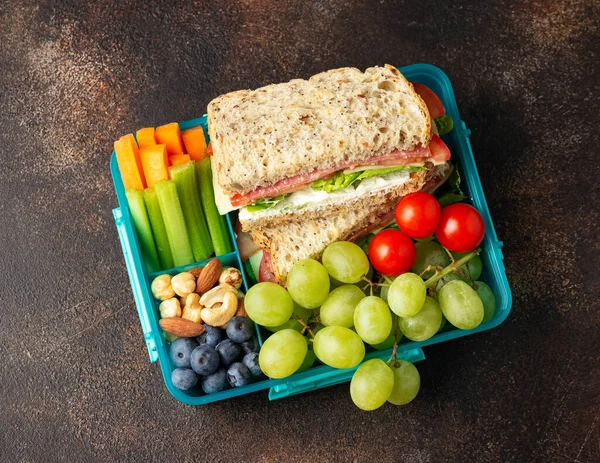 School, work lunch box with sandwiches and fresh vegetables, nuts and fruits. Healthy food.