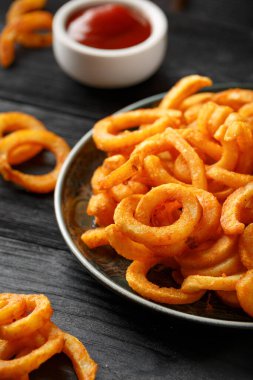 Kırsal tabakta ketçaplı altın kıvırcık patates kızartması.