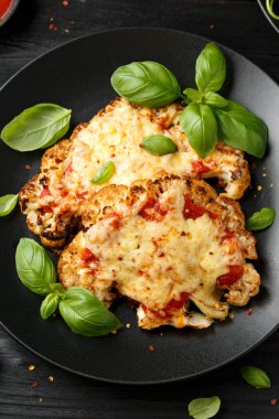 Marinara soslu ve peynirli fırında karnabahar bifteği. Sağlıklı vejetaryen yemekleri