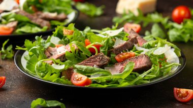 İtalyan biftekli Tagliata salatası, yaban roketi, vişneli domates ve parmesan peyniri.