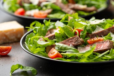 İtalyan biftekli Tagliata salatası, yaban roketi, vişneli domates ve parmesan peyniri.