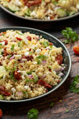 Kurutulmuş domatesli kuskus salatası, salatalık, kırmızı soğan ve peynir. sağlıklı yiyecekler.