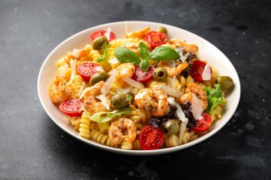 Salamura edilmiş yeşil zeytinli, kiraz domatesli ve parmesan peynirli makarna salatası. Sağlıklı yemek..