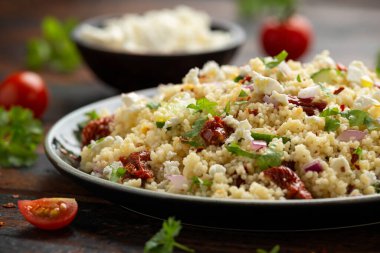 Kurutulmuş domatesli kuskus salatası, salatalık, kırmızı soğan ve peynir. sağlıklı yiyecekler.