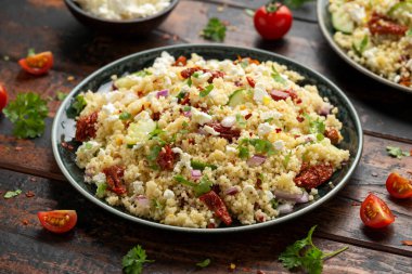 Kurutulmuş domatesli kuskus salatası, salatalık, kırmızı soğan ve peynir. sağlıklı yiyecekler.