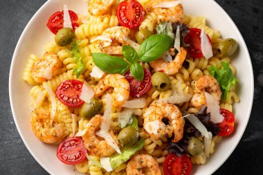 Salamura edilmiş yeşil zeytinli, kiraz domatesli ve parmesan peynirli makarna salatası. Sağlıklı yemek..