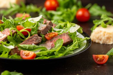 İtalyan biftekli Tagliata salatası, yaban roketi, vişneli domates ve parmesan peyniri.