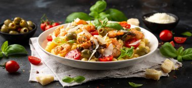 Salamura edilmiş yeşil zeytinli, kiraz domatesli ve parmesan peynirli makarna salatası. Sağlıklı yemek..