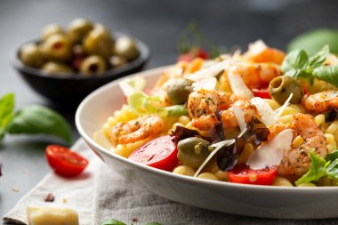 Salamura edilmiş yeşil zeytinli, kiraz domatesli ve parmesan peynirli makarna salatası. Sağlıklı yemek..