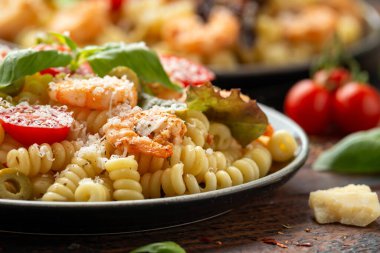 Salamura edilmiş yeşil zeytinli karidesli makarna salatası, vişneli domates ve parmesan peyniri.