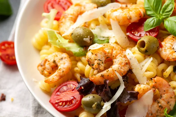 Salamura edilmiş yeşil zeytinli, kiraz domatesli ve parmesan peynirli makarna salatası. Sağlıklı yemek..