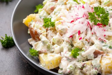 Kerevizli patates salatası, yeşil soğan, turp, dereotu ve yumurta.