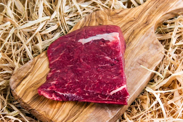 Британський яловичини плоского заліза стейк на обробна дошка та соломи — стокове фото