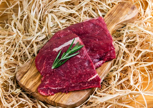 Boeuf britannique steak plat en fer sur planche à découper et paille, oignon — Photo