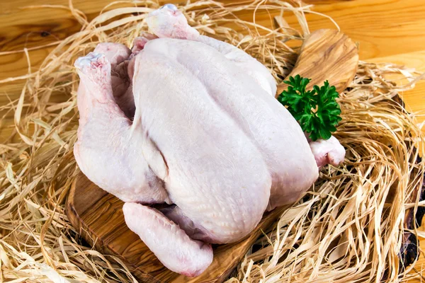 Pollo intero allevato all'aperto su tagliere e paglia — Foto Stock