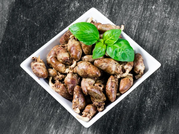 Fresh cooked chicken hearts seasoned with pepper and salt ready to eat. basil leaf decoration. Background, Texture