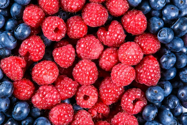 Nahaufnahme von frischen Bio-Blaubeeren und Himbeeren. reich an Vitaminen Hintergrund, Textur — Stockfoto