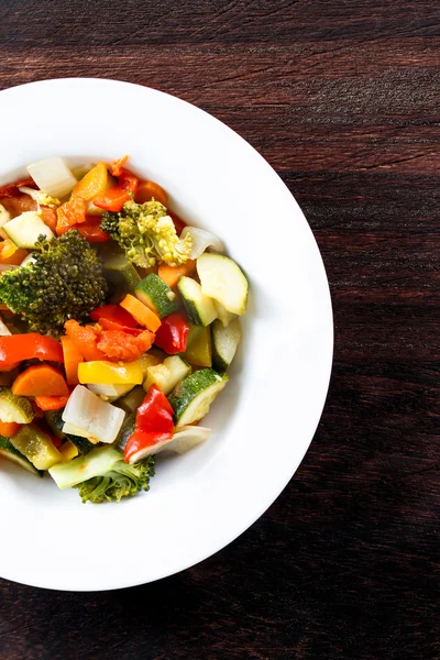 Gekookte geroosterde groenten gestoofd tomaten, wortelen, paprika's, Courgettes, broccoli, UI op platen. — Stockfoto