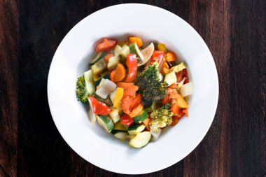 Pişmiş kavrulmuş sebze demlenmiş domates, havuç, biber, kabak, brocoli, soğan plakaları.