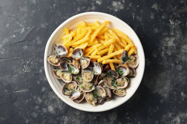 Steamed Clams with herbs and French fries in a white plate.