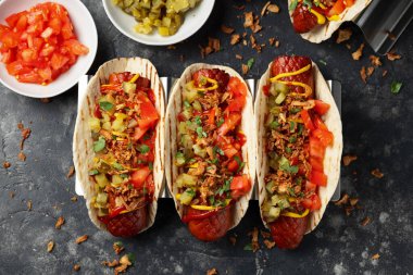 Sosisli, turşulu, domatesli ve kızarmış soğanlı Taco Hot Dog..