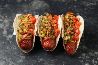 Sosisli, turşulu, domatesli ve kızarmış soğanlı Taco Hot Dog..