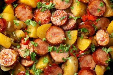 Koyu ahşap masada kızarmış patates ve sosis..