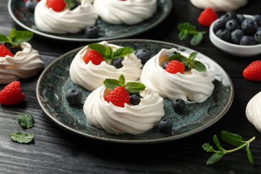 Meringue yuvaları, kremalı mini pavlova keki, taze böğürtlen, yabanmersini, ahududu ve nane şekeri sağlıklı çöl için.