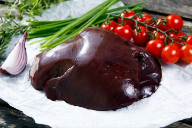 Pişmemiş karaciğer üzerinde buruşuk kağıt, Yeşiller ve sebze ile dekore edilmiştir. eski ahşap tablo