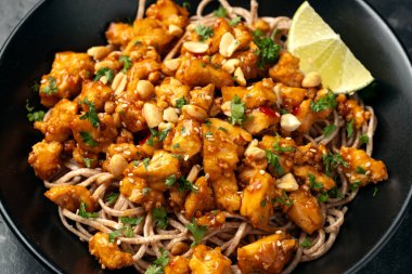 Tofu eriştesi Kızartma ve ballı sarımsak sosu siyah kasede.