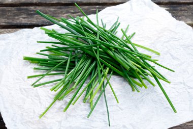 Taze yeşil sebze grup, Chives buruşuk kağıt ve eski ahşap masa.