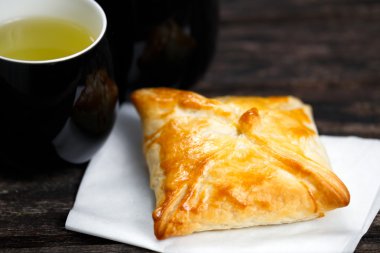 Eski ahşap masa üzerinde sığır eti, patates ve soğan ve yeşil çay bardağı ile ev yapımı pasta