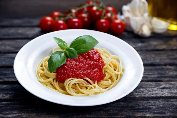 Spaghetti mit Marinara-Sauce und Basilikumblättern darauf, dekoriert — Stockfoto